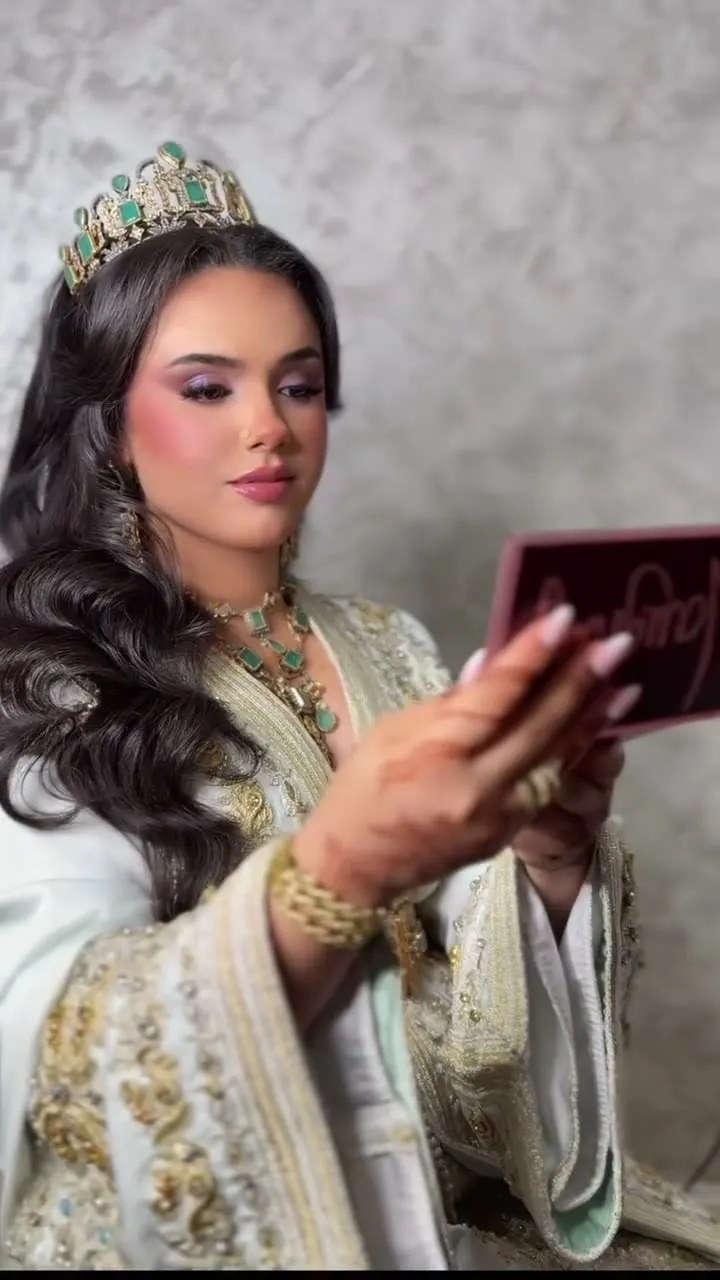 Novia marroquí con corona y caftán bordado en oro, maquillaje glam