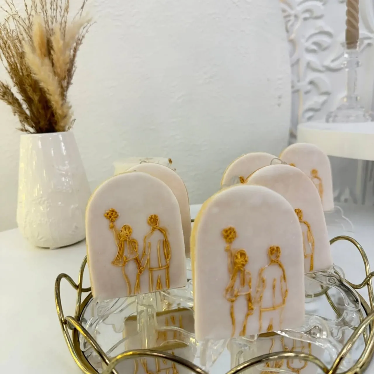 Galletas artesanas con silueta de pareja pintada en oro
