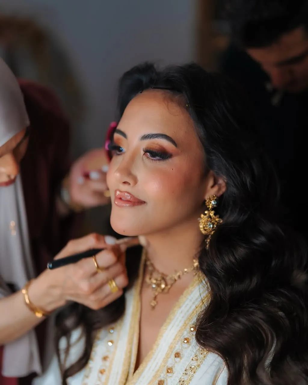 Primer plano de novia marroquí con maquillaje nupcial y joyas doradas
