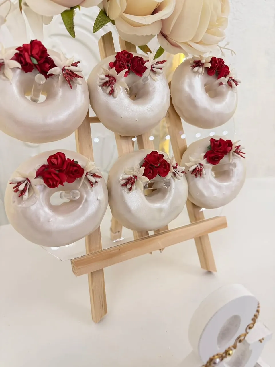 Cake pops con rosas rojas en caballete de madera